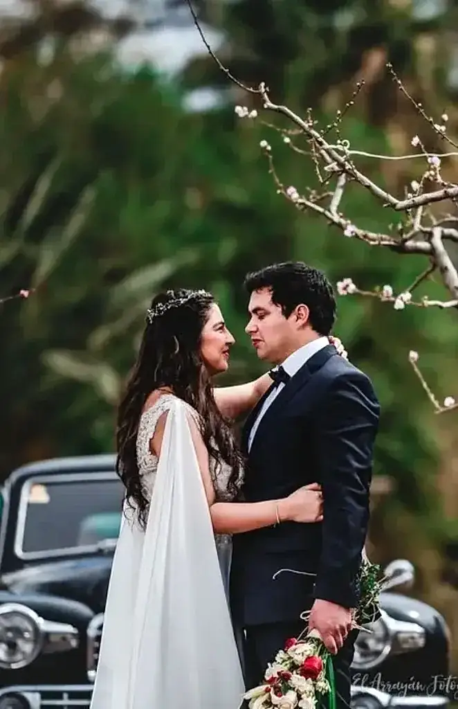 Matrimonio joven posando junto árbol de damasco en la ciudad de Los Andes, Valparaíso