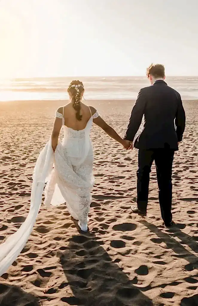Novios caminando por la playa el día de su boda